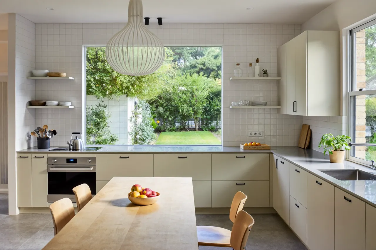 Kitchen diner with a wide new window framing the garden view